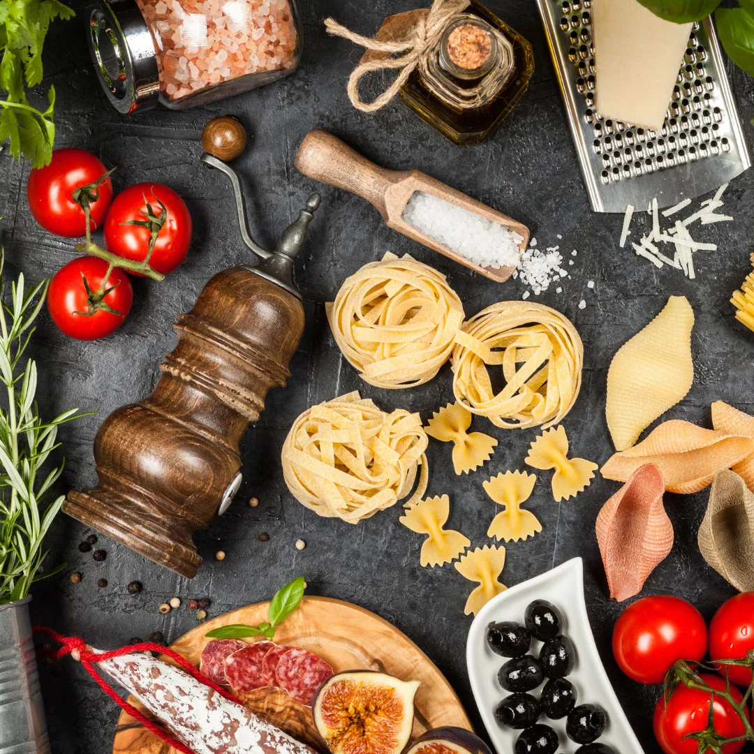 Assorted Italian pasta, fresh tomatoes, cured meats, olives, and cooking ingredients for professional foodservice operations.
